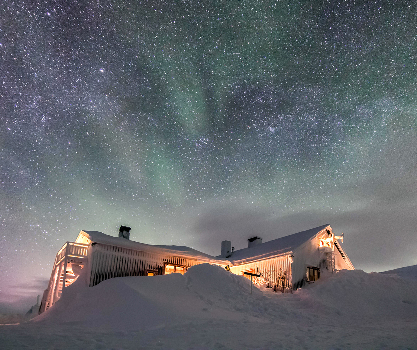 Låktatjåkko fjällstation en vintrig och norrskensklar kväll